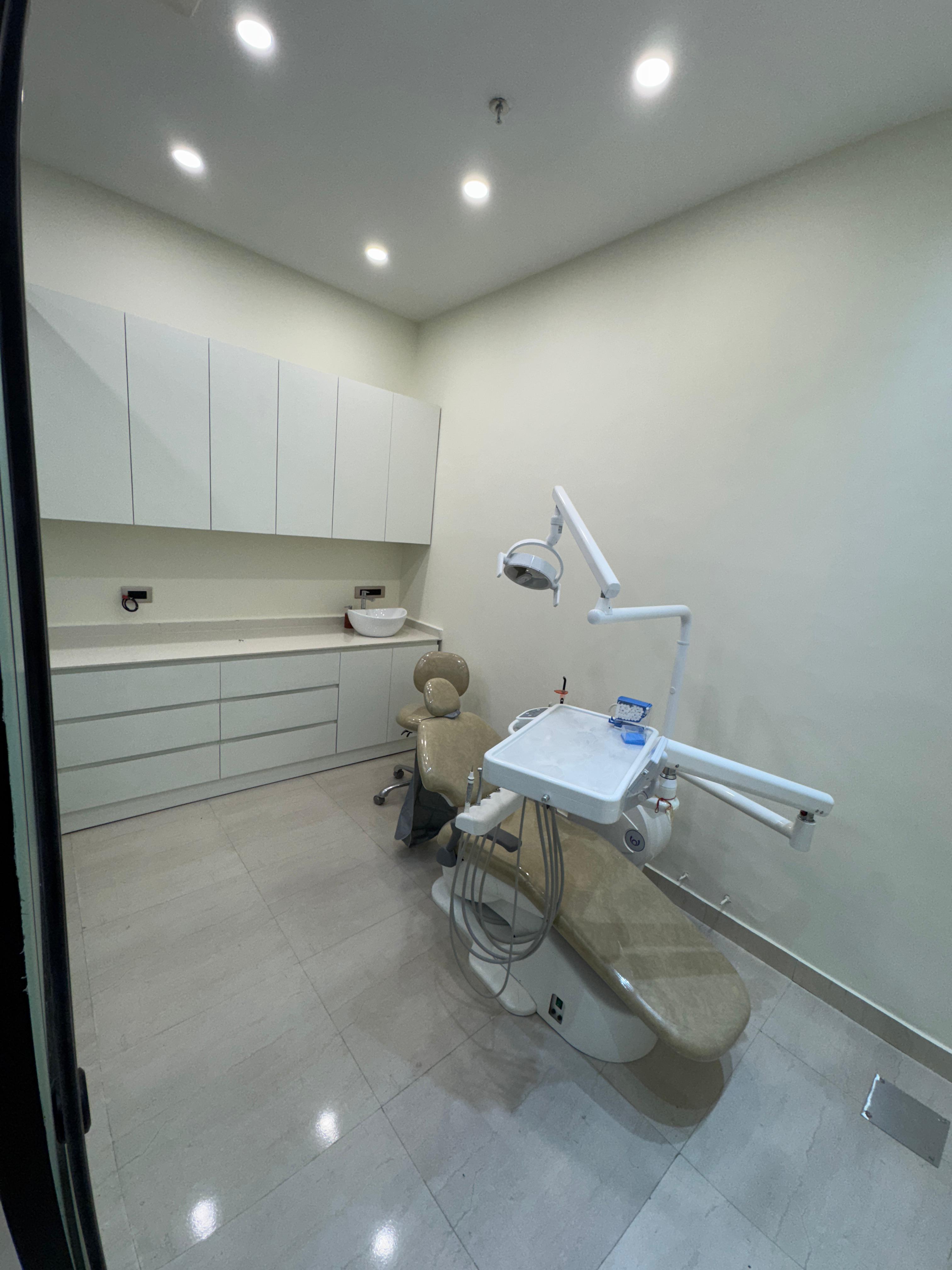 Modern dental treatment room with dental chair and equipment